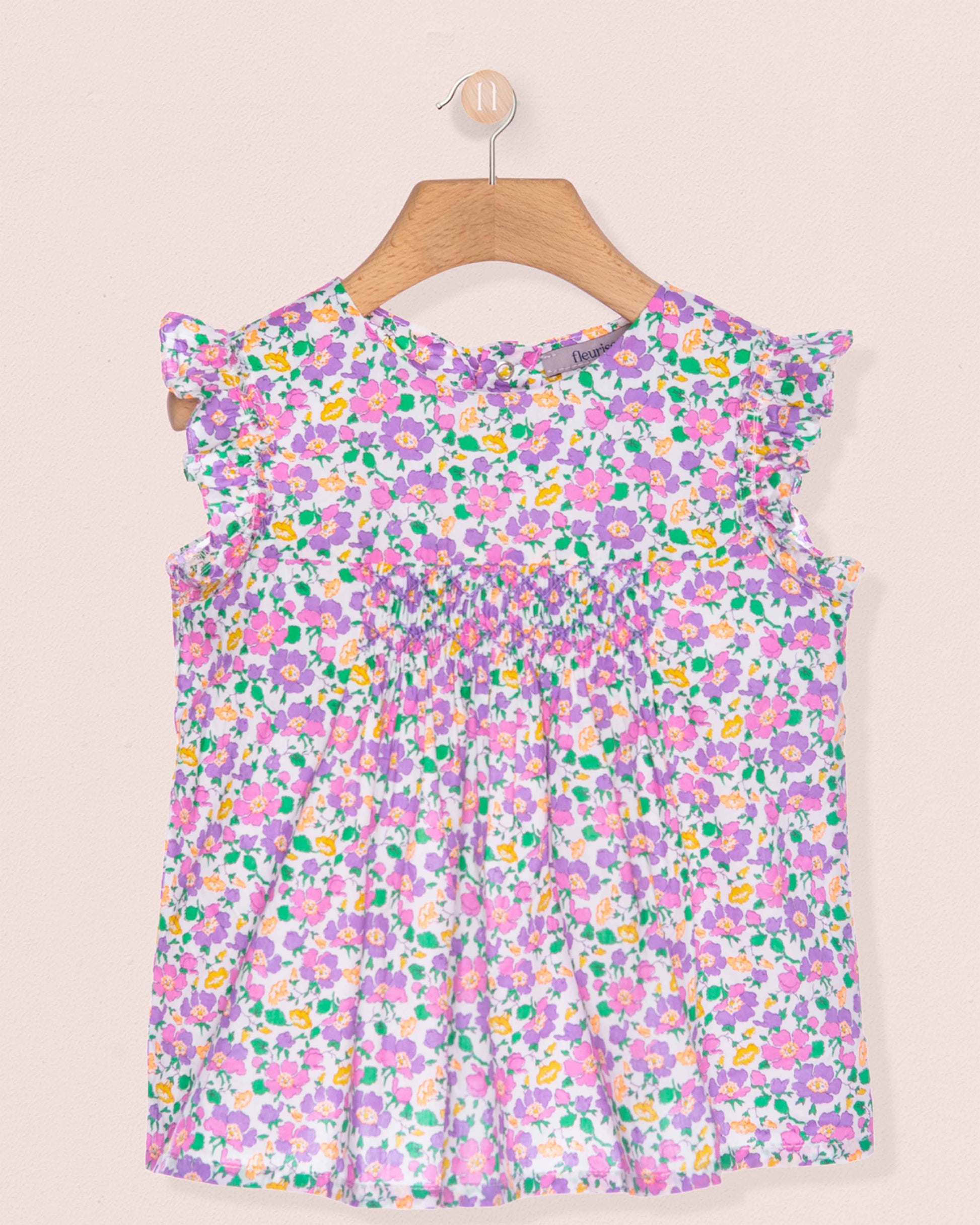 Floral dress on a hanger against a beige background