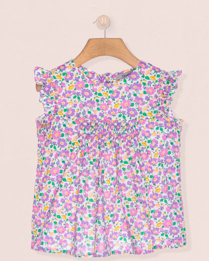 Floral dress on a hanger against a beige background