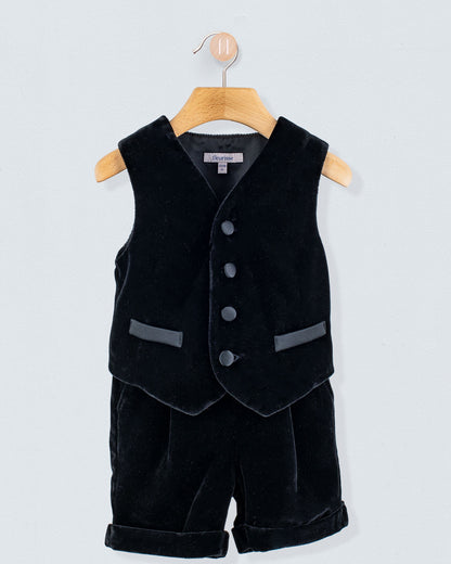 Adam 2-Piece Black Velvet Vest and Suspender Shorts, infant-sized, featuring a sleeveless V-neck vest with buttons and matching shorts with turned-up cuffs and suspenders.