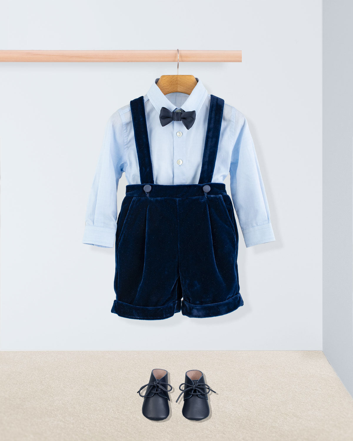 Adam Navy Velvet Suspender Short paired with a light blue shirt, black bow tie, and navy lace-up shoes, showcasing elegant Italian craftsmanship for special occasions.