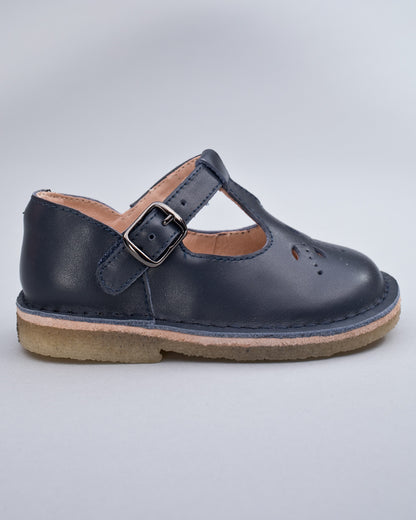 Side profile of a navy leather crepe sole toddler shoe with velcro strap and buckle detail