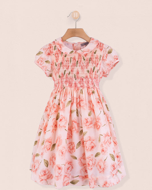 Front view of Amanda Bianca rose smock dress hanging on a wooden hanger