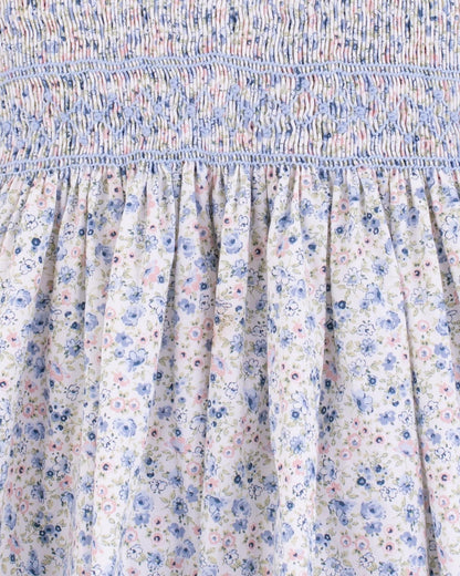 Close-up of the hand-smocked bodice and top portion of the gathered skirt of the Amandine Florencia Blue Floral Dress, highlighting the detailed blue and light blue stitching.