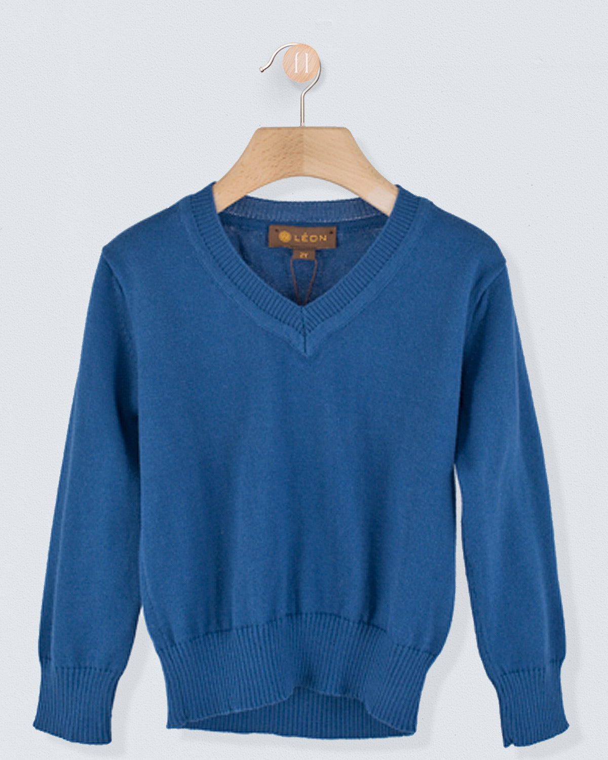 ront view of the Arnaud Cotton Sweater in summer navy with a V-neckline and ribbed cuffs and hem hanging on a wooden hanger