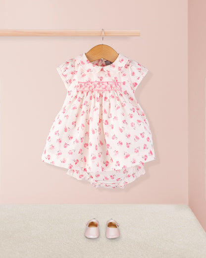 Front view of the Baby Eva Versaille Rose Octuouse dress set styled with pink shoes and laid out for display, showing pleated design and pink floral smocking detail.