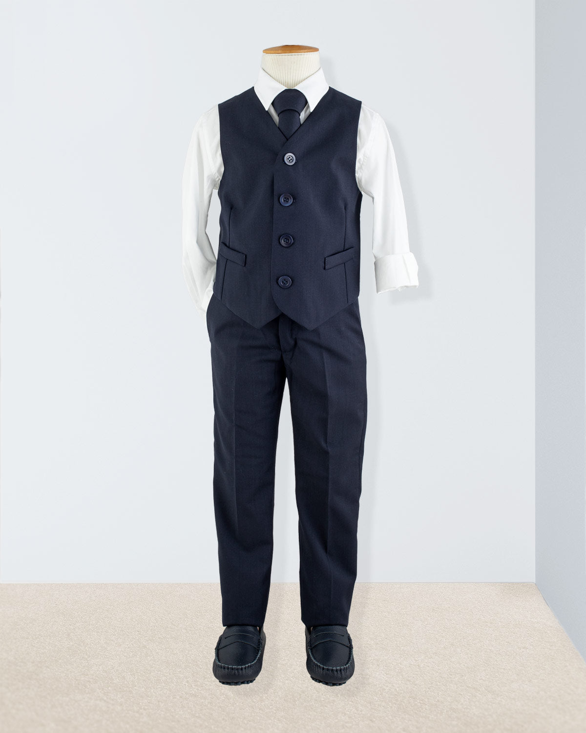Navy vest styled on a child mannequin with white shirt and black tie for formalwear look