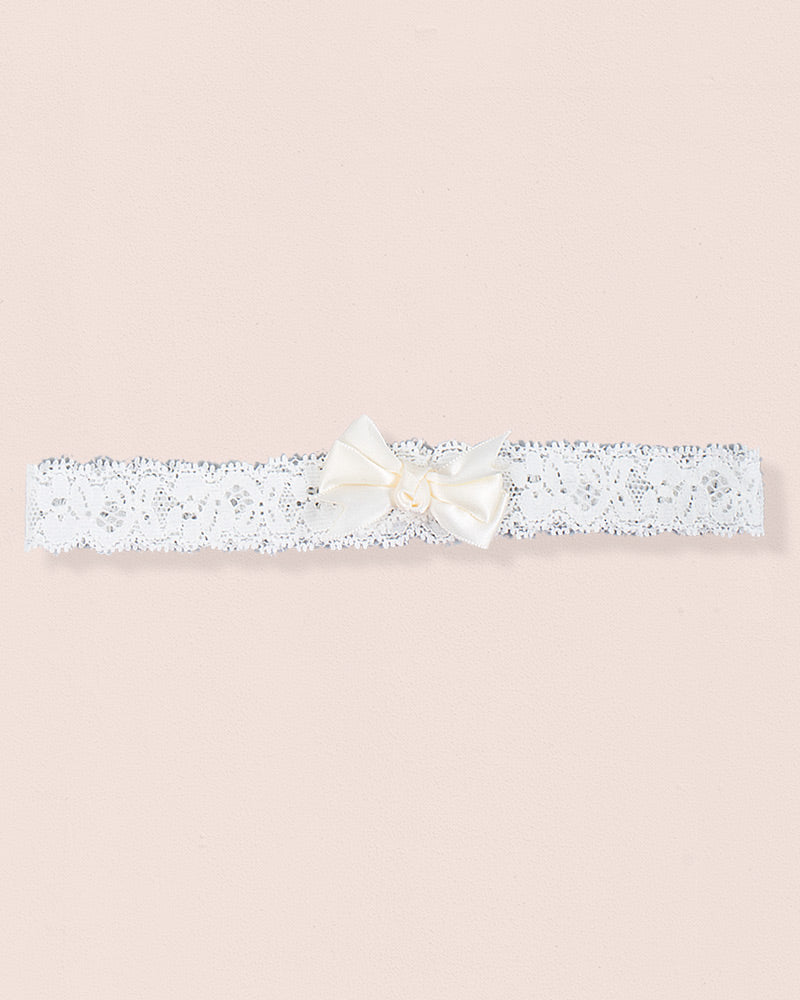 Cream baby headband made of lace with a centered satin bow displayed on a neutral background