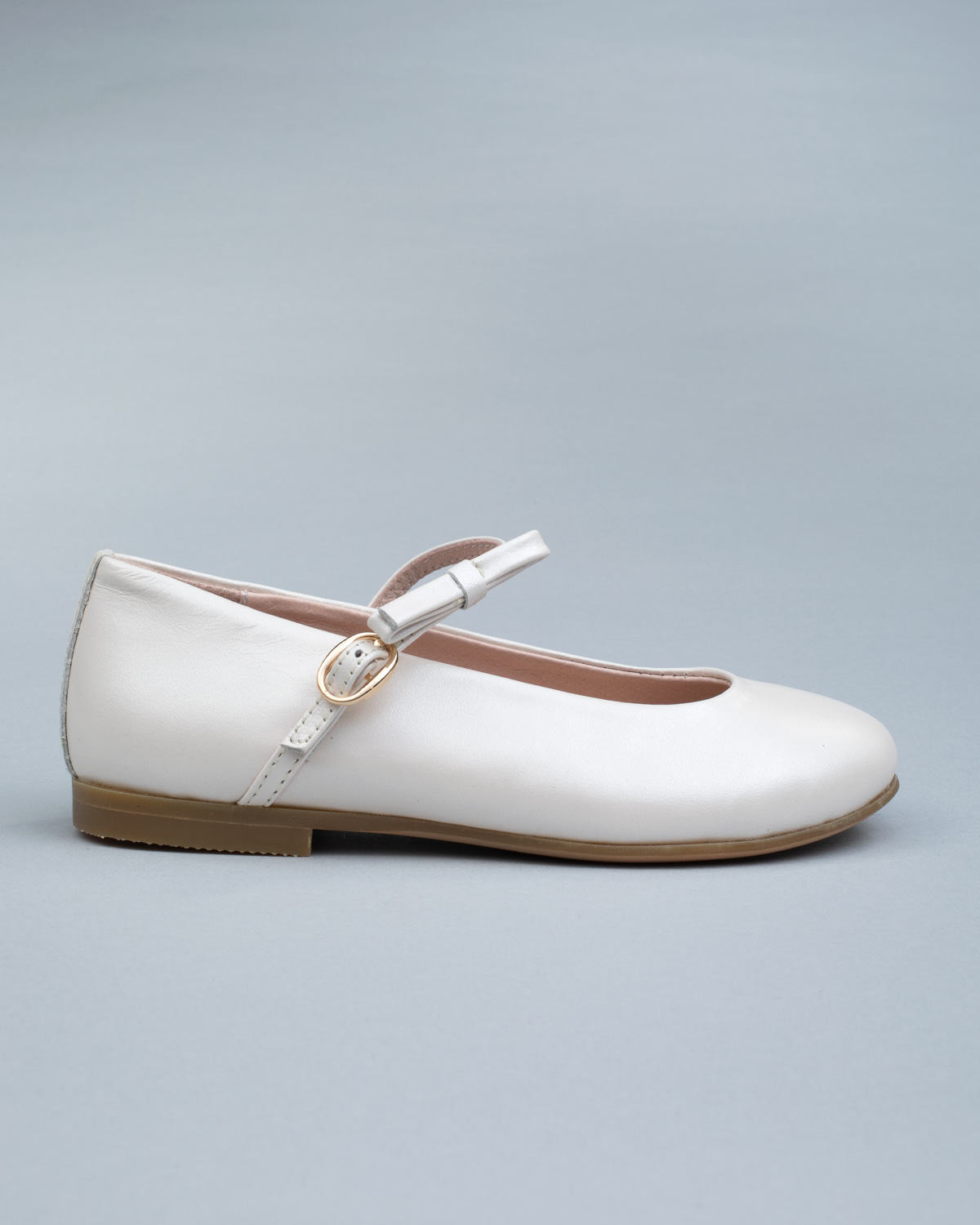 Single cream leather Mary-Jane shoe for kids shown from the side, featuring a soft bow and a secure buckle strap.