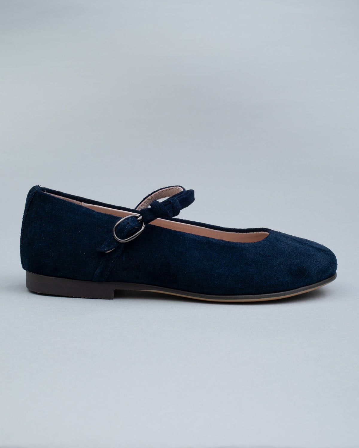Single navy suede Mary-Jane shoe for kids shown from the side, featuring a soft bow and a secure buckle strap.
