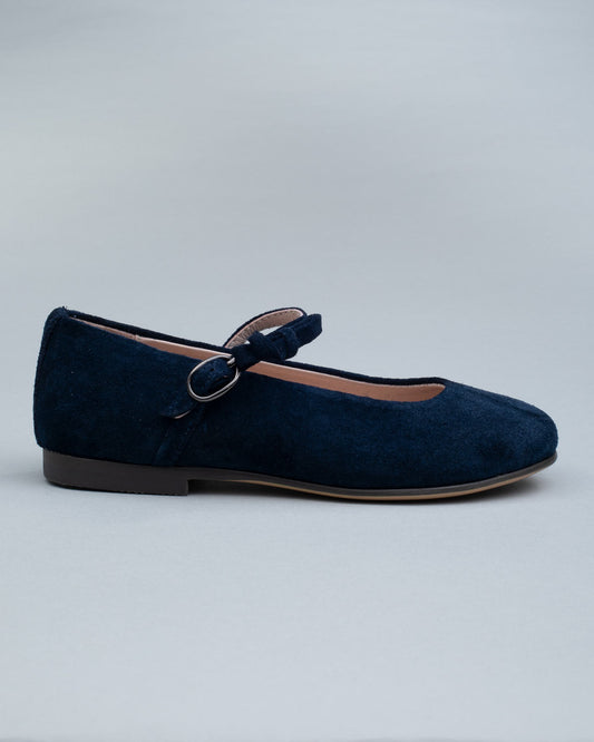 Single navy suede Mary-Jane shoe for kids shown from the side, featuring a soft bow and a secure buckle strap.