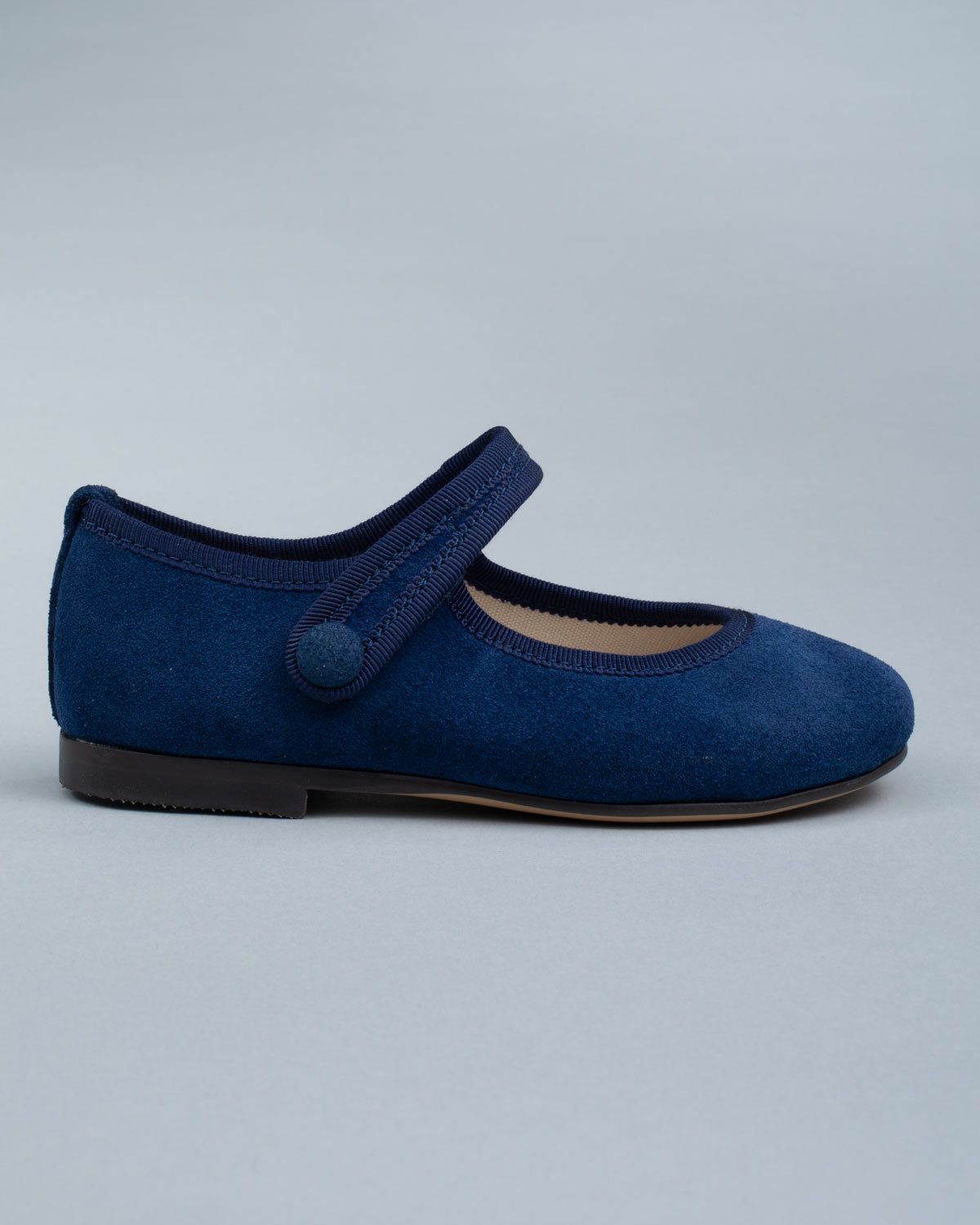 Side profile of a single Elizabeth Twilight Blue Suede Mary-Jane shoe showing velcro strap and soft suede texture.