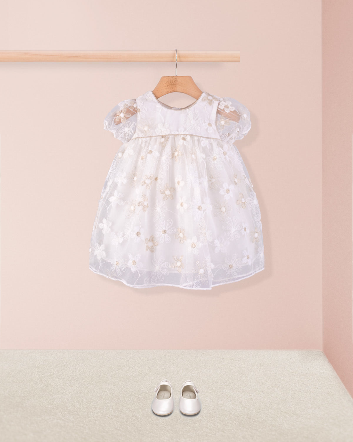 Full front view of Baby Isodora Cream Tulle Dress styled with cream baby shoes on beige carpet and soft pink wall background.