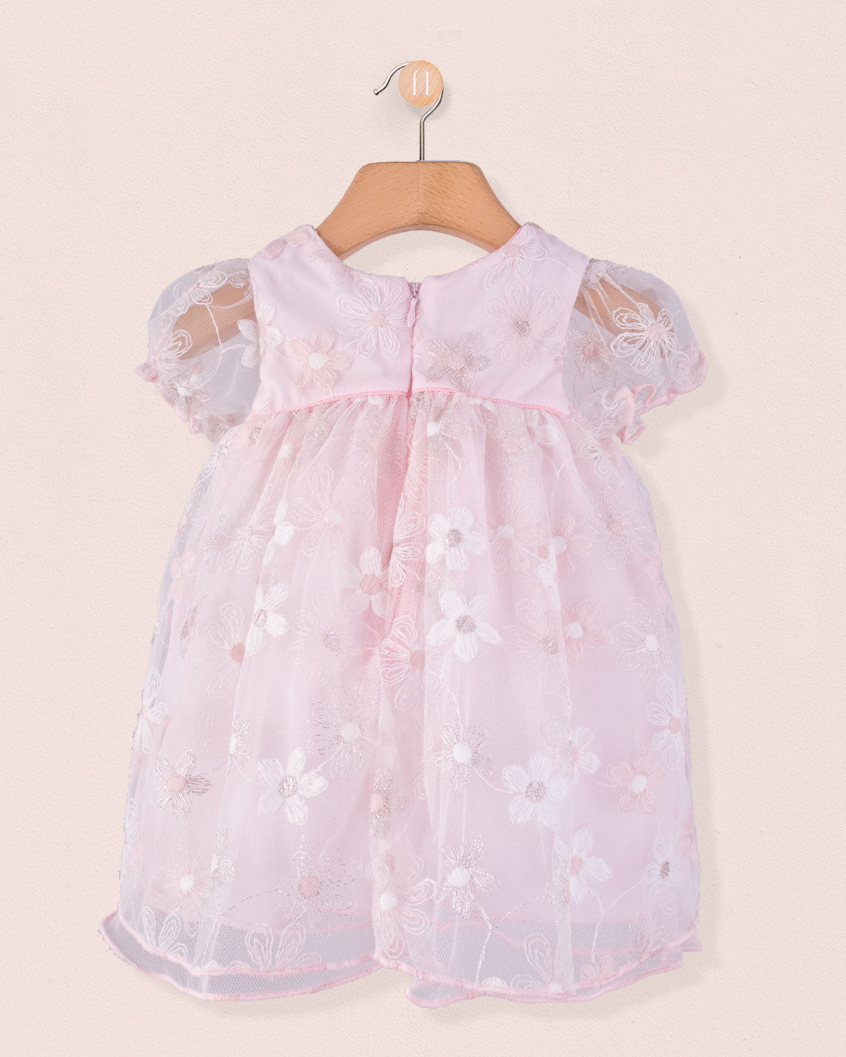 Back view of Baby Isodora pink Tulle Dress with embroidered mesh overlay, zipper closure, and gathered waist, hung on a wooden hanger.