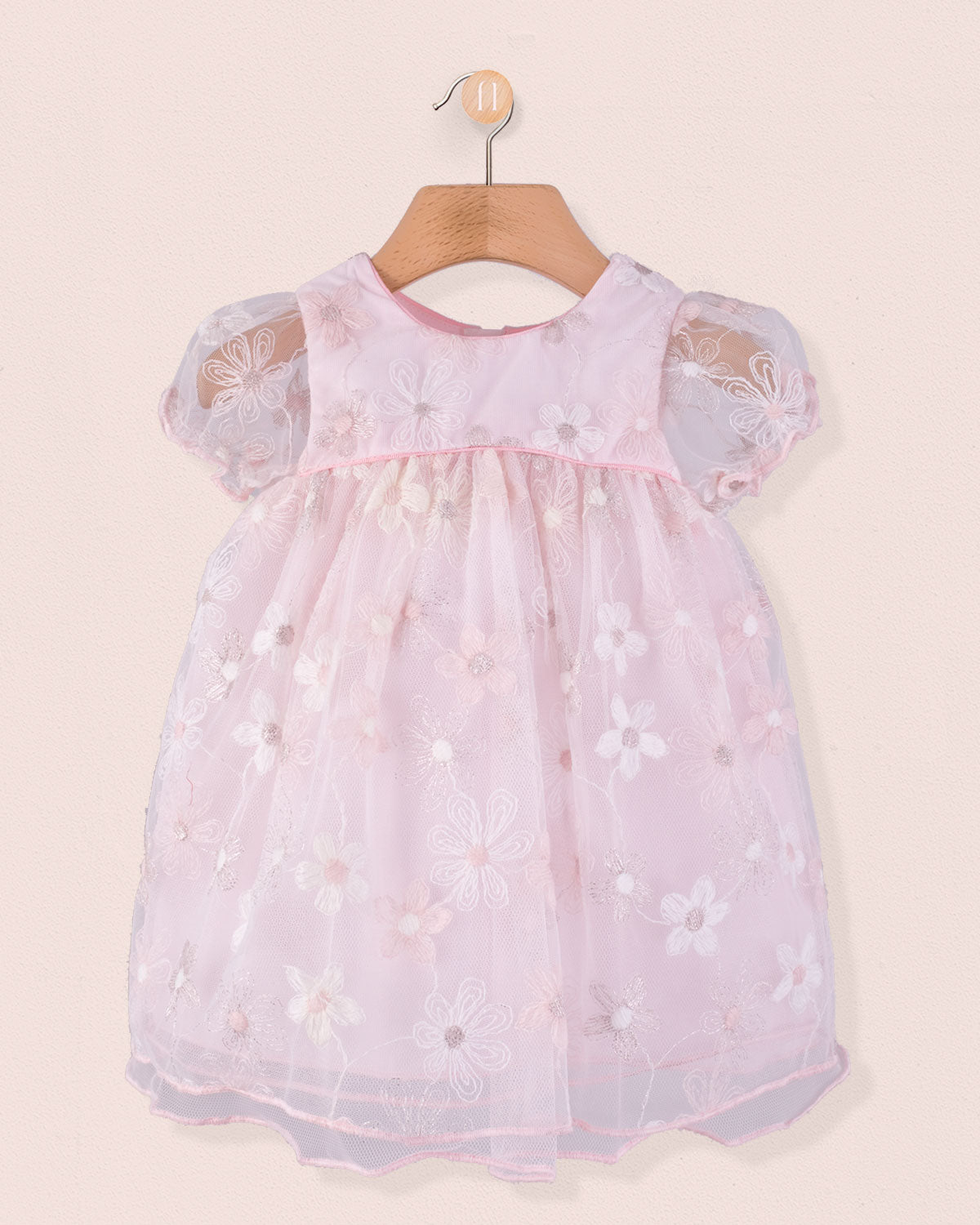 Front view of Baby Isodora Embroidered pink Tulle Dress featuring short puff sleeves, delicate floral embroidery, and soft mesh overlay, displayed on wooden hanger.