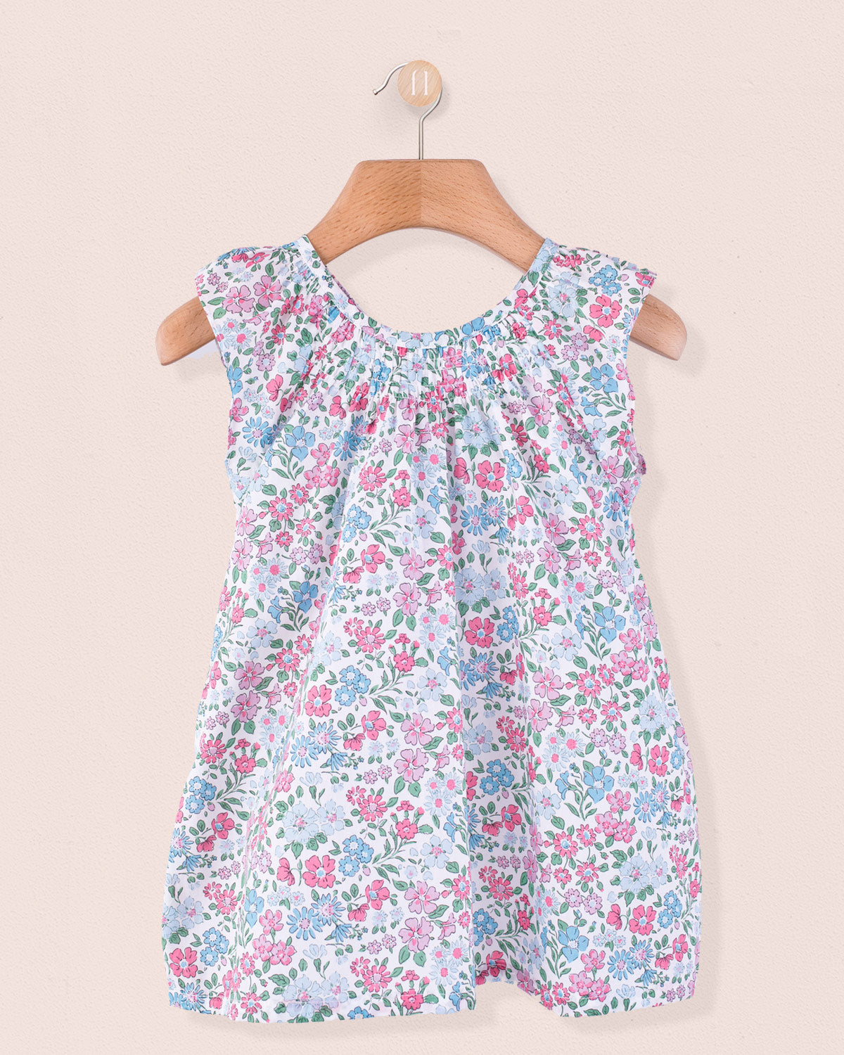 Sleeveless floral shift-style tunic in Liberty of London cotton on wooden hanger.