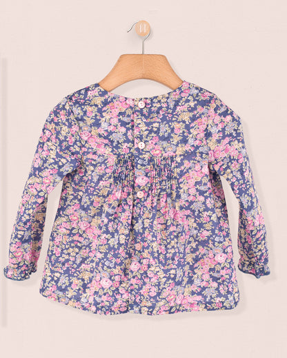 Back view of baby tunic in Liberty Tatum Blue floral cotton with dyed-to-match buttons and gathered detailing.