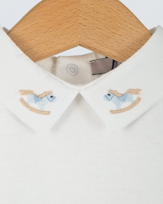 Close-up of the Andreas Baby Onesie’s collar, showing two light blue rocking horse embroideries on each side of the pointed collar.