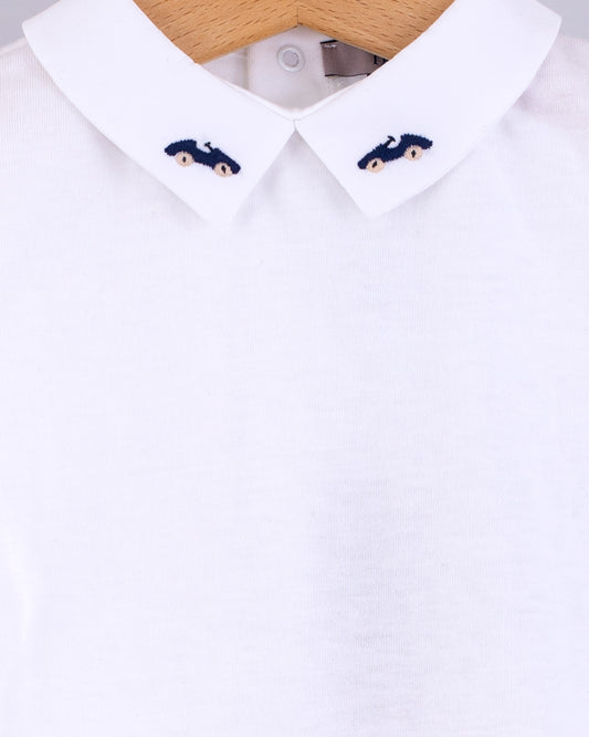 Close-up of the Andreas Baby Onesie’s collar, showing two navy cars with beige wheels  embroideries on each side of the pointed collar.