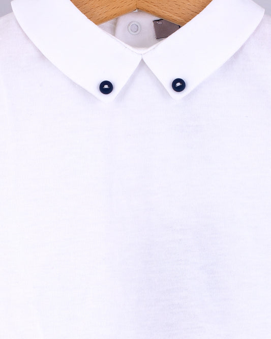 Close-up of the Andreas Onesie collar showing two small navy corzo buttons stitched into the tips of the white collar.