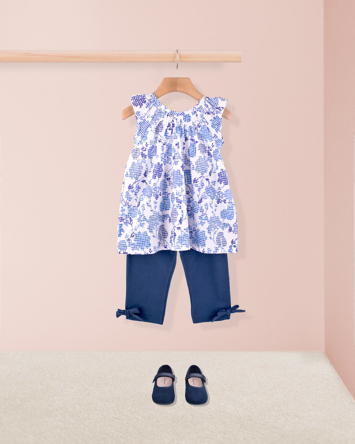 Alicia Royal Tunic styled with navy capri leggings  and Mary Jane shoes on display.