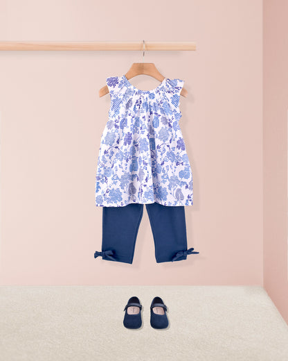 Alicia Royal Tunic styled with navy capri leggings  and Mary Jane shoes on display.