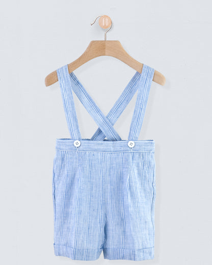 Front view of blue striped linen suspender shorts with crossed buttoned straps and cuffed hem, displayed on a hanger