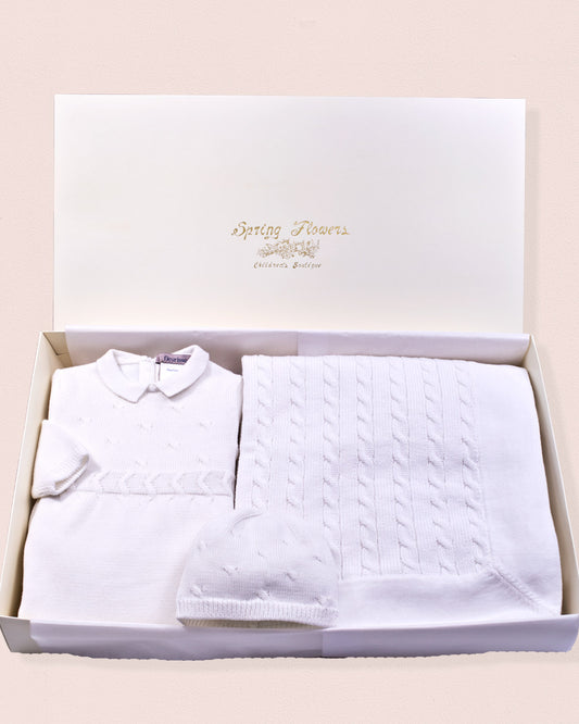 Close-up of the Take Me Home White Knit Collection romper, showcasing the white collared knit romper, featuring leg snaps, matching hat and a blanket.