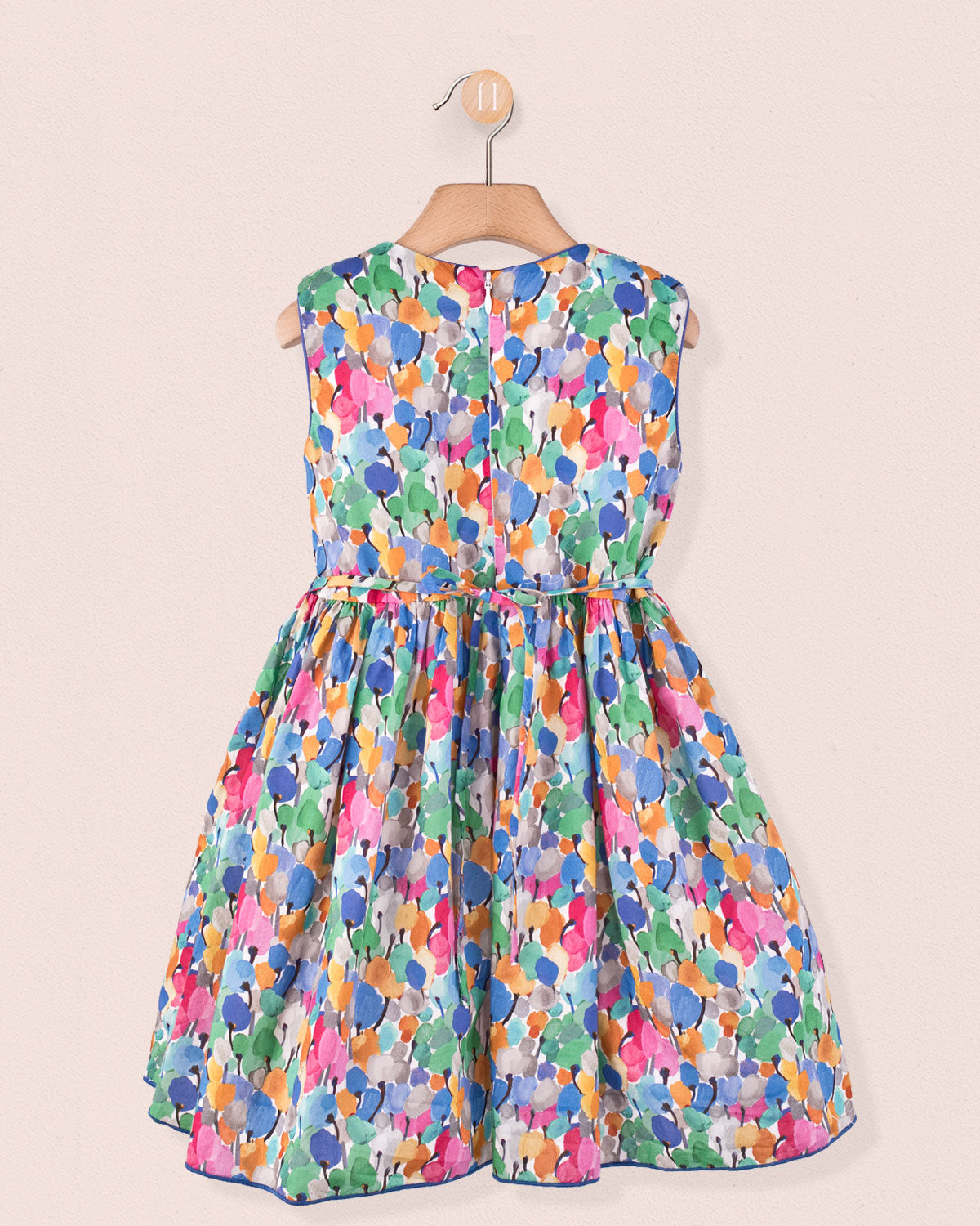 ack view of the Amandine Liberty Tulip Fields Blue Smock dress showing a zip closure and the same vibrant tulip Liberty print, displayed on a wooden hanger.