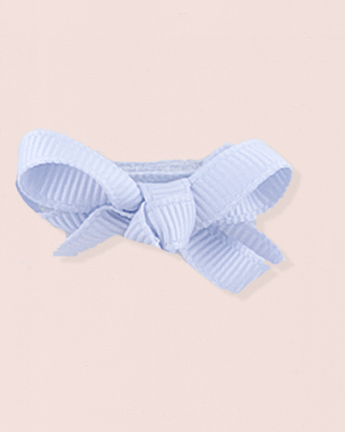 Close-up of a single light blue grosgrain baby hairbow attached to velcro, displayed against a light pink 