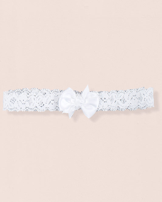 White baby headband made of lace with a centered satin bow displayed on a neutral background